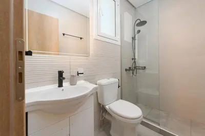a bathroom with a sink and a toilet and a shower at Luxury Penthouse Maisonette Nearby Acropolis in Athens