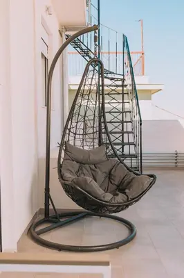 a hanging chair in a room with a staircase at Luxury Penthouse Maisonette Nearby Acropolis in Athens