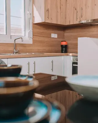 a kitchen with wooden cabinets and a sink and bowls at Luxury Penthouse Maisonette Nearby Acropolis in Athens