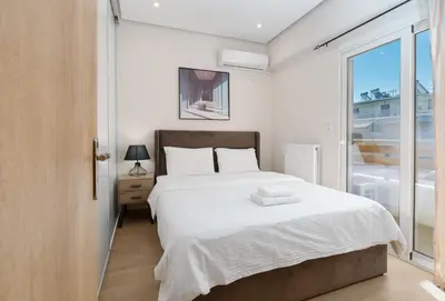 a bedroom with a large white bed and a window at Luxury Penthouse Maisonette Nearby Acropolis in Athens