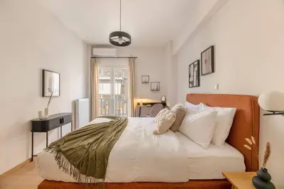 a bedroom with a large bed with white sheets and pillows at Koukaki 2BR Apartment by UPSTREET in Athens