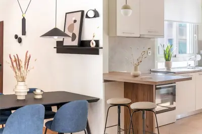 a kitchen with a table and blue chairs at Koukaki 2BR Apartment by UPSTREET in Athens