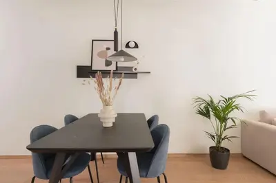 a dining room with a black table and blue chairs at Koukaki 2BR Apartment by UPSTREET in Athens