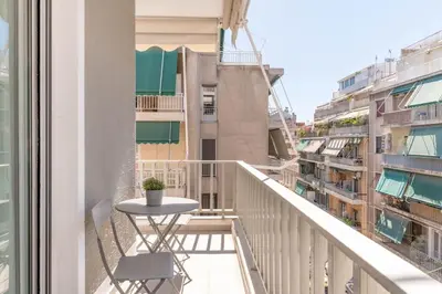 a balcony with a table and chairs on a building at Koukaki 2BR Apartment by UPSTREET in Athens
