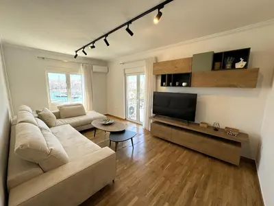a living room with a couch and a flat screen tv at Piraeus center sea view apartment in Piraeus