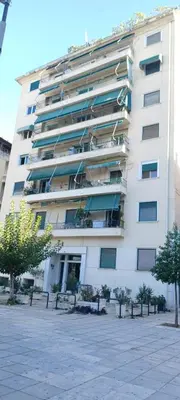 a large white building with trees in front of it at Piraeus center sea view apartment in Piraeus