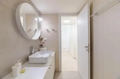 a white bathroom with a sink and a mirror at The HostMaster Ethereal Scene in Athens