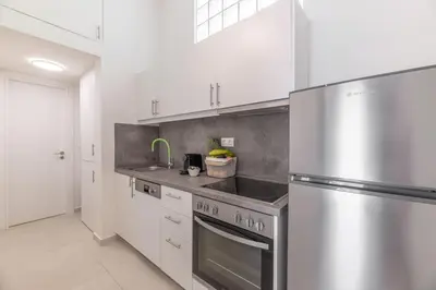 a kitchen with a stainless steel refrigerator and white cabinets at The HostMaster Ethereal Scene in Athens