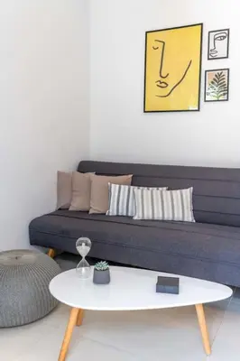 a living room with a couch and a white table at The HostMaster Ethereal Scene in Athens