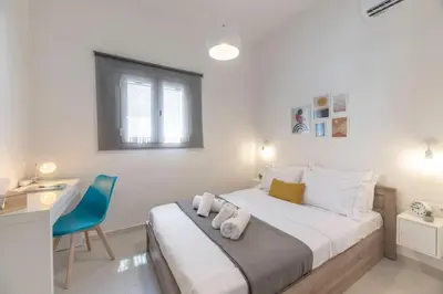 a bedroom with a bed with a desk and a blue chair at The HostMaster Ethereal Scene in Athens