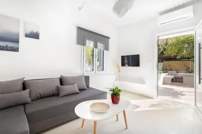 a living room with a couch and a table at The HostMaster Aethereal Style in Athens