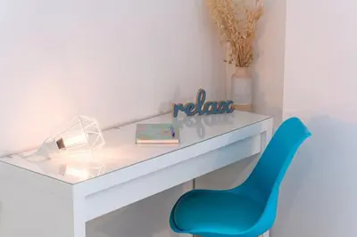 a white desk with a blue chair in a room at The HostMaster Aethereal Style in Athens