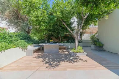 a patio with a table and a tree at The HostMaster Aethereal Style in Athens