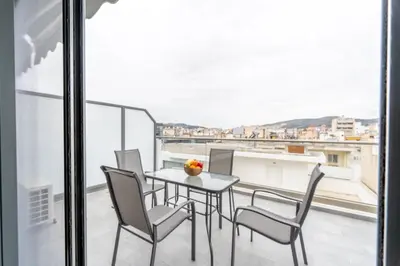 a table and chairs on a balcony with a view at IAIRA in Athens