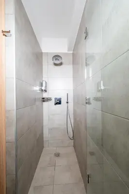 a shower with a glass door in a bathroom at IAIRA in Athens