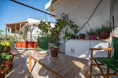 a balcony with a wooden table and potted plants at N kosmos metro st 1 bedroom 4 pers flat by MPS in Athens