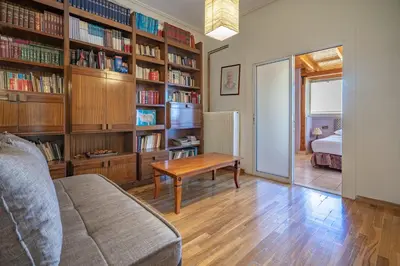 a living room with a couch and a table and bookshelves at N kosmos metro st 1 bedroom 4 pers flat by MPS in Athens