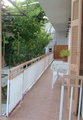 a balcony with a white railing and a table at George's Apartment in Agia Marina Aegina