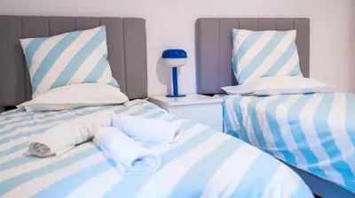 two beds in a room with blue and white stripes at Cozy Apartment in Athens Center in Athens
