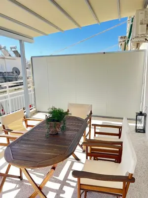 a wooden table and chairs on a balcony at Cozy apartment with big veranda near Athens centre and metro tram in Athens