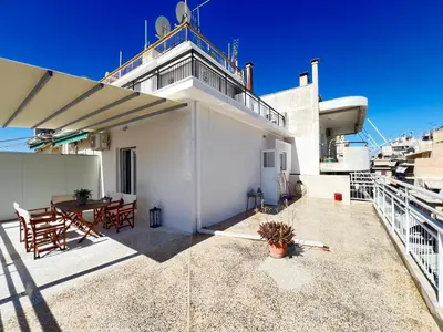 a patio with a table and chairs on a building at Cozy apartment with big veranda near Athens centre and metro tram in Athens