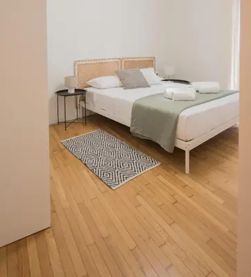 a bedroom with a large bed and a wooden floor at Athens Secret Gem in Athens