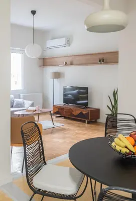 a living room with a table and chairs and a television at Athens Secret Gem in Athens