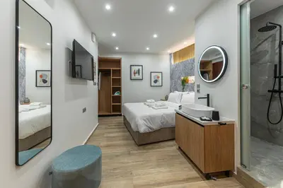 a bathroom with a bed and a sink and a mirror at Stylish Living-Avra in Athens