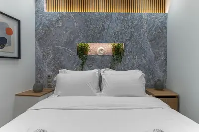 a bedroom with a bed with white pillows at Stylish Living-Avra in Athens