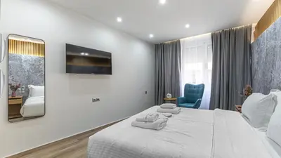a bedroom with a white bed and a blue chair at Stylish Living-Ioli in Athens