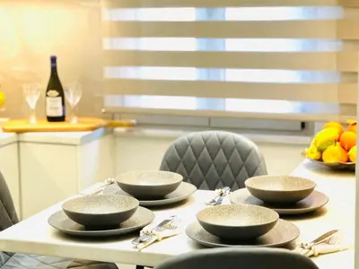 a table with bowls and chairs and a bottle of wine at Modern home in Athens