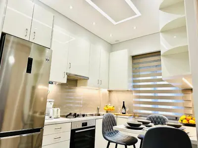 a kitchen with white cabinets and a table and chairs at Modern home in Athens