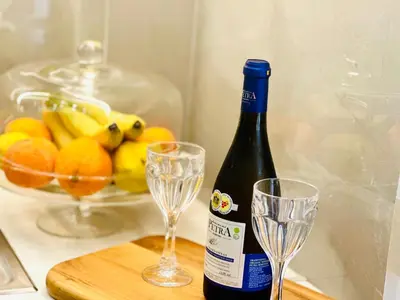 a bottle of wine and two glasses on a cutting board at Modern home in Athens