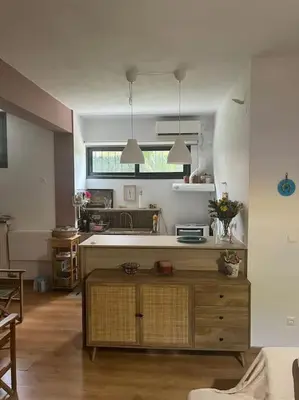 a kitchen with a table in the middle of a room at Διαμέρισμα στην Άνω Ηλιούπολη in Athens