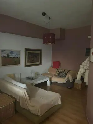 a living room with two beds and a table at Διαμέρισμα στην Άνω Ηλιούπολη in Athens