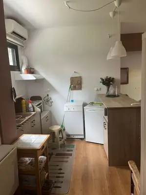 a kitchen with white appliances and a wooden floor at Διαμέρισμα στην Άνω Ηλιούπολη in Athens