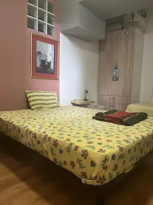 a bedroom with a bed with a yellow blanket at Διαμέρισμα στην Άνω Ηλιούπολη in Athens