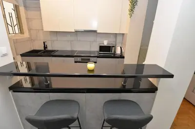 a kitchen with two chairs and a counter top at Zen Oasis Apartment in Athens