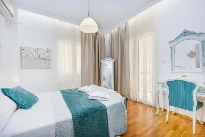 a bedroom with a bed and a table and a chair at Athenian Oasis Near Athens Metro Mall in Athens