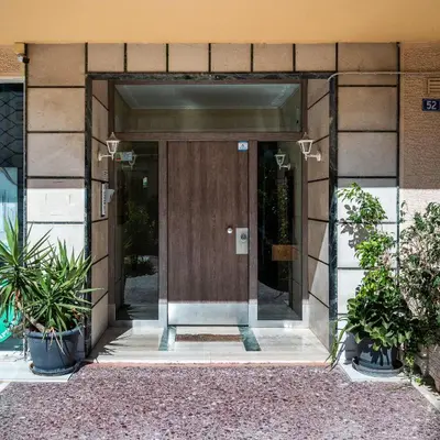 an entrance to a building with a wooden door at Athenian Oasis Near Athens Metro Mall in Athens