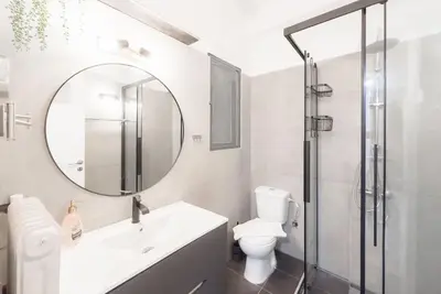 a bathroom with a toilet and a sink and a mirror at Spacious Urban Apt in the Heart of Athens in Athens