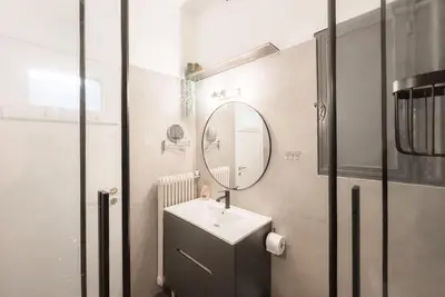 a bathroom with a sink and a mirror at Spacious Urban Apt in the Heart of Athens in Athens