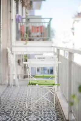 a green and white chair sitting on a balcony at Spacious Urban Apt in the Heart of Athens in Athens
