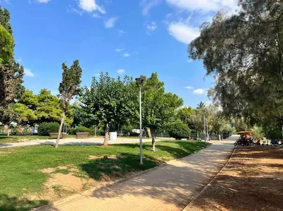 a park with people sitting on a bench in the grass at Exclusive 2 bed Luxury Panorama in Athens