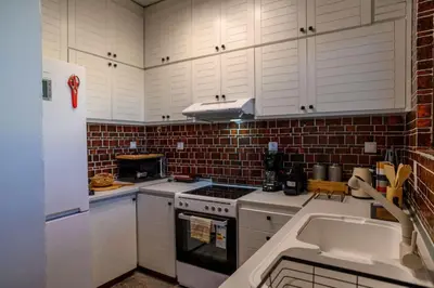 a kitchen with white cabinets and a stove top oven at Exclusive 2 bed Luxury Panorama in Athens