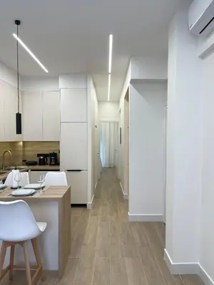 a kitchen with white cabinets and a table and chairs at Aurora apartment , in the Heart of Athens in Athens