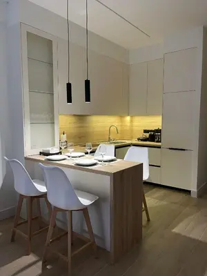 a kitchen with white cabinets and a island with chairs at Aurora apartment , in the Heart of Athens in Athens