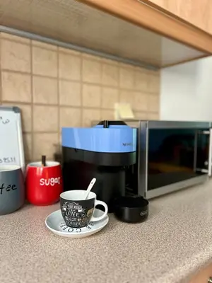 a coffee cup on a plate next to a microwave at Sunny Modern Beach Retreat Steps from the Shore in Saronida