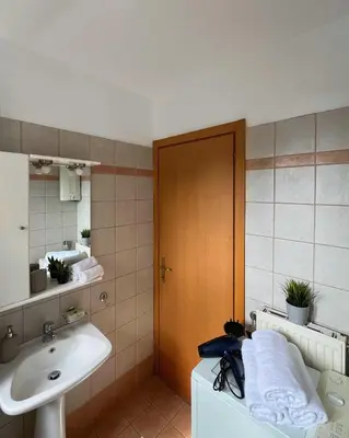 a bathroom with a sink and a toilet and a mirror at Sunny Modern Beach Retreat Steps from the Shore in Saronida