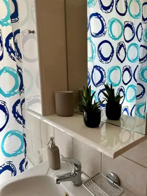 a bathroom with a sink and a mirror and plants at Sunny Modern Beach Retreat Steps from the Shore in Saronida